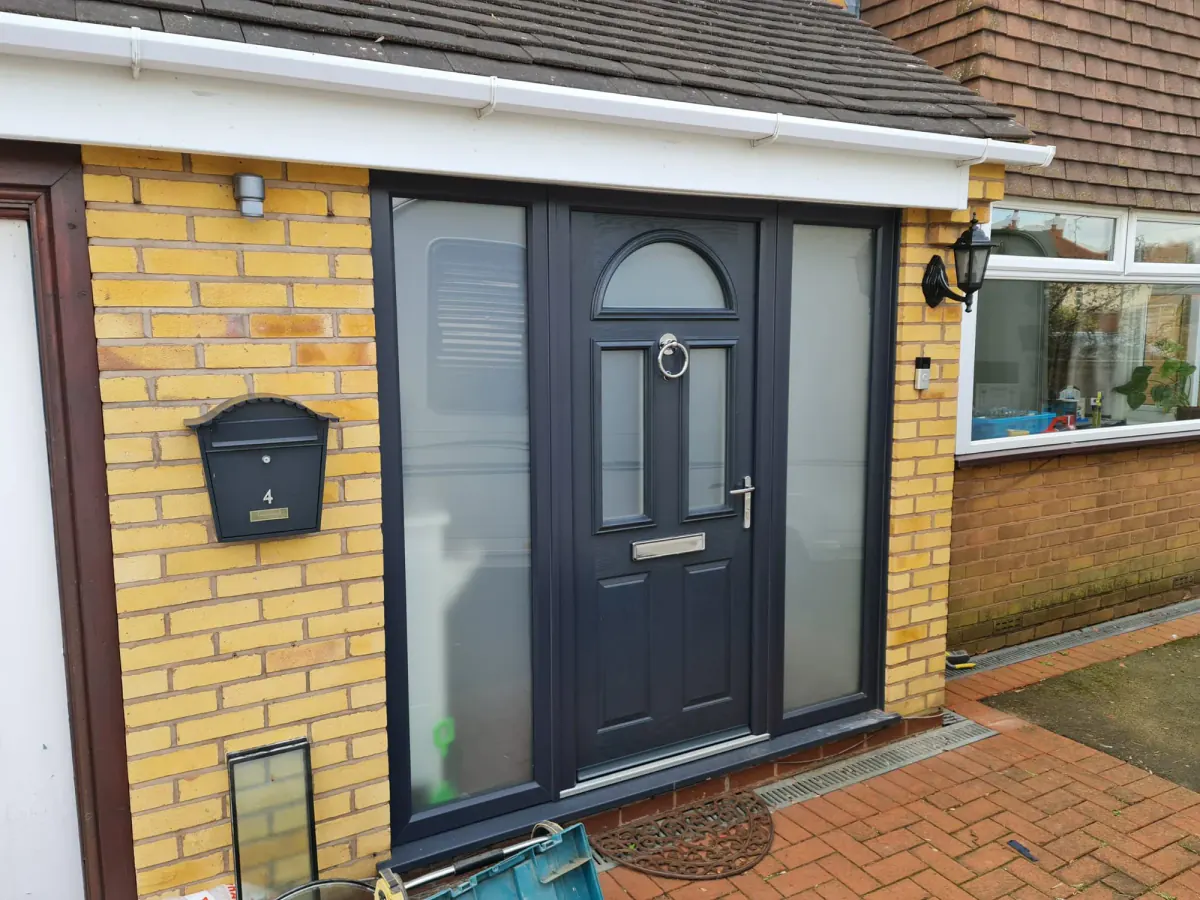 Black composite entrance door with glazed side panels installed by Prime Windows